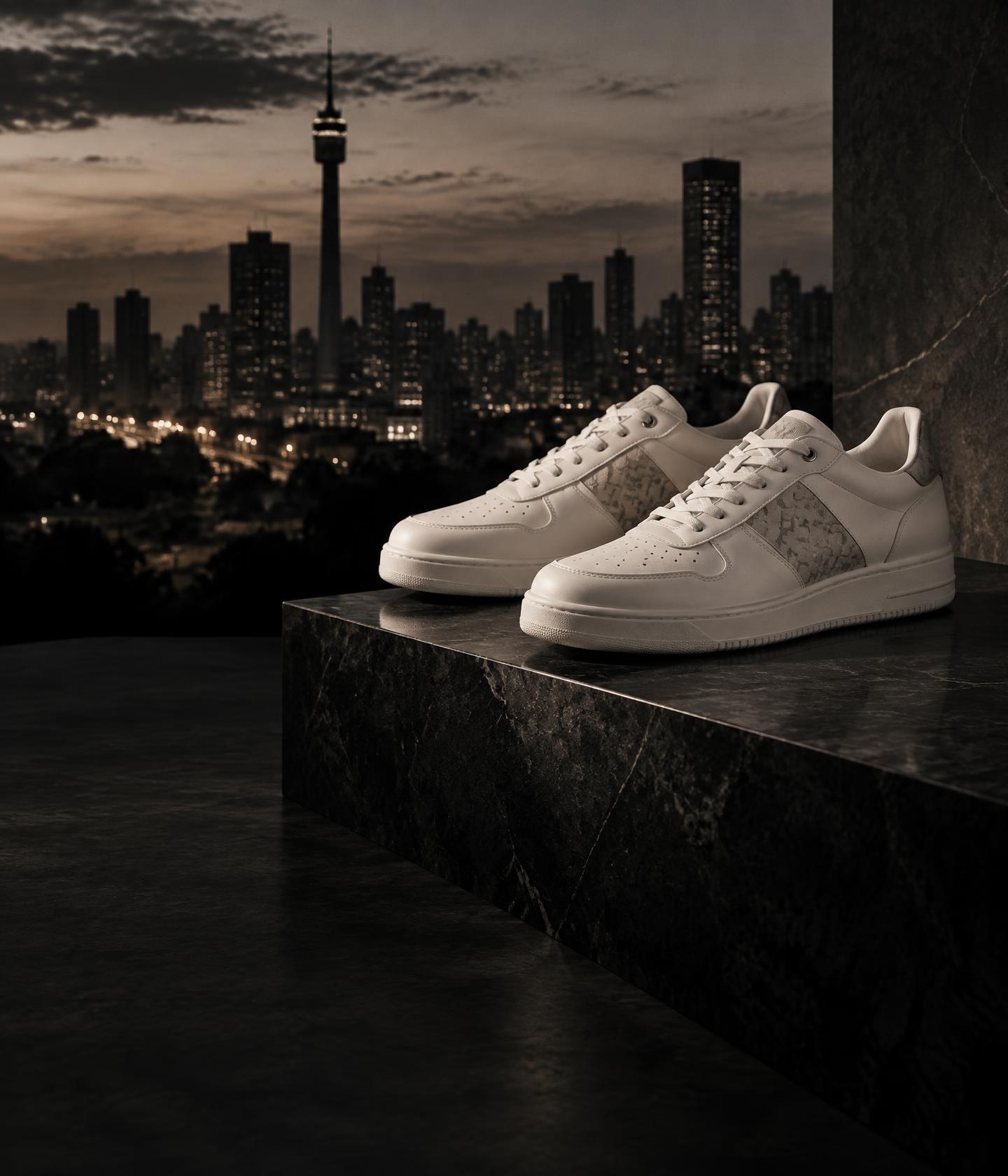 Luxury sneakers on a stone pedestal against a city skyline
